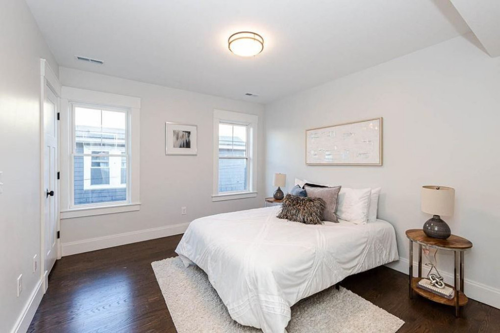 Design ideas for a mid-sized modern guest bedroom in Boston with white walls, dark hardwood floors and brown floor.