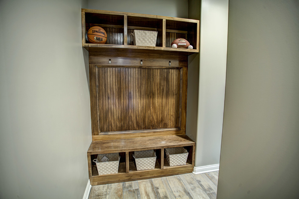 Mid-sized transitional medium tone wood floor and gray floor foyer photo with gray walls and a brown front door