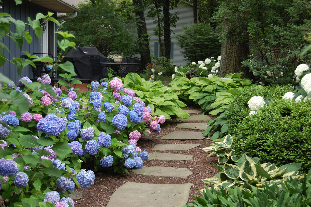 Photo of a traditional backyard shaded garden in Chicago with a garden path and natural stone pavers.