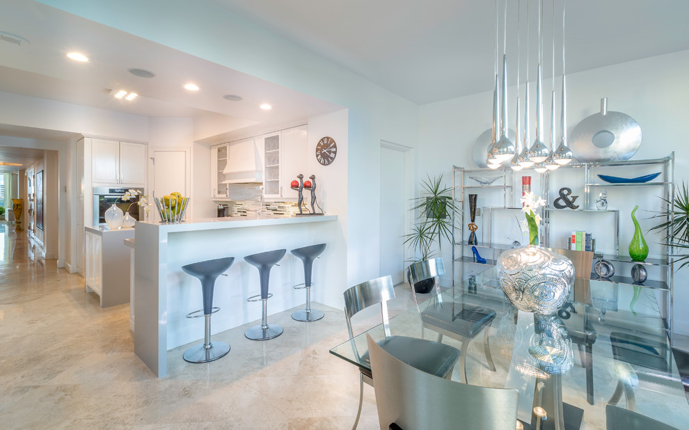 This is an example of a small modern u-shaped eat-in kitchen in Miami with glass-front cabinets, white cabinets, granite benchtops, grey splashback, matchstick tile splashback, stainless steel appliances, a peninsula and an undermount sink.