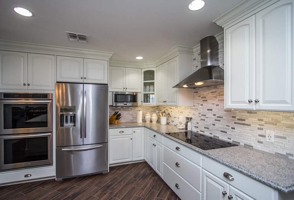 Large transitional u-shaped dark wood floor and brown floor enclosed kitchen photo in Phoenix with raised-panel cabinets, white cabinets, granite countertops, multicolored backsplash, matchstick tile backsplash and stainless steel appliances
