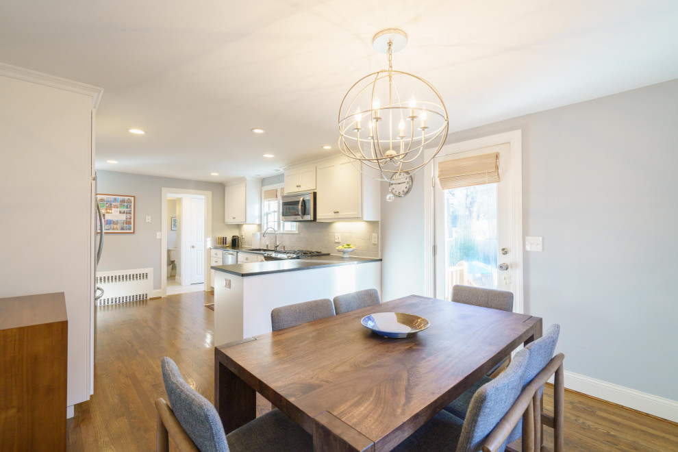 Small transitional u-shaped medium tone wood floor and brown floor eat-in kitchen photo with an undermount sink, shaker cabinets, white cabinets, granite countertops, white backsplash, marble backsplash, stainless steel appliances, a peninsula and black countertops