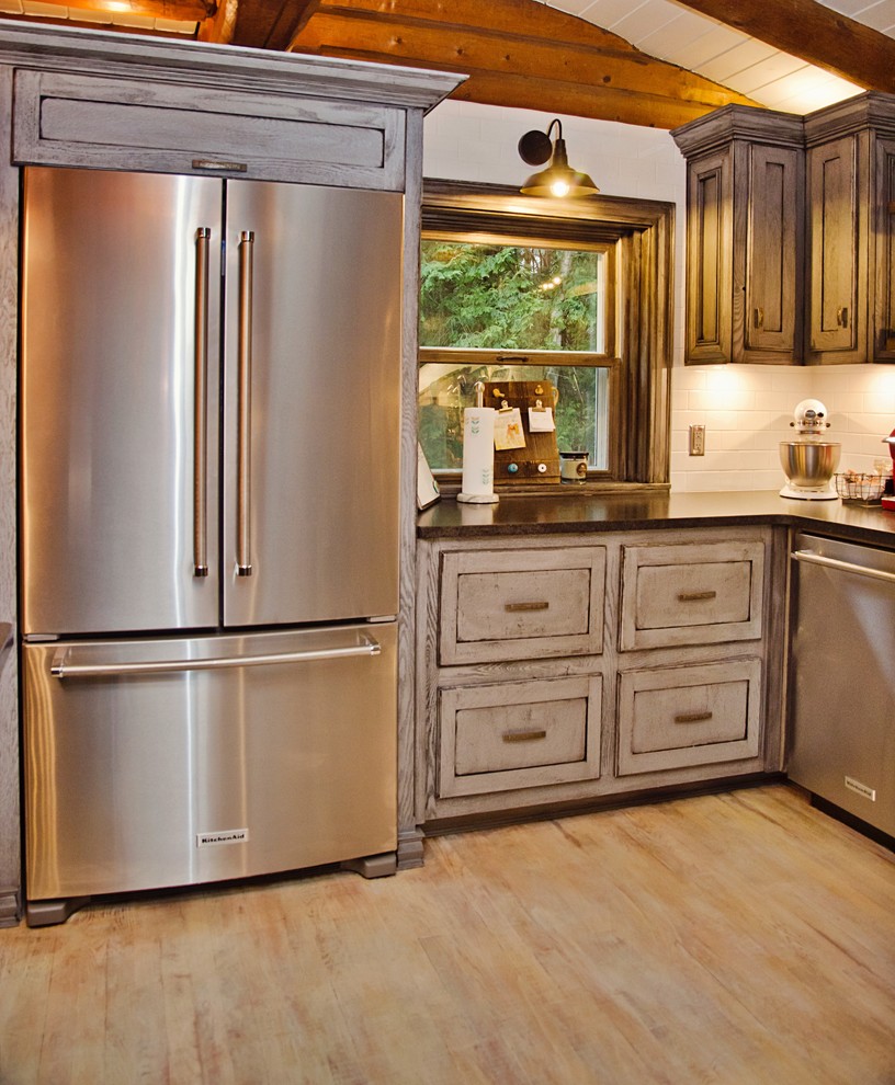 Inspiration for a mid-sized craftsman u-shaped light wood floor and white floor eat-in kitchen remodel with a farmhouse sink, recessed-panel cabinets, gray cabinets, granite countertops, white backsplash, cement tile backsplash, stainless steel appliances and an island