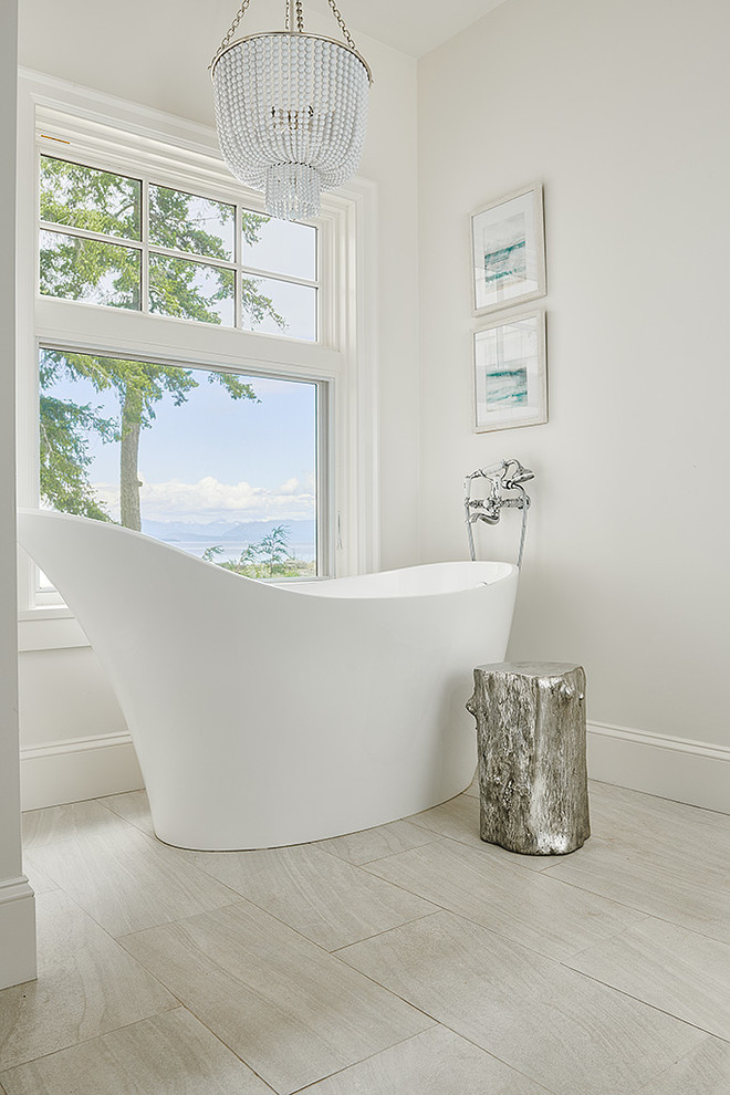 Photo of a large beach style master bathroom in Vancouver with a freestanding tub, porcelain floors, beige floor and white walls.