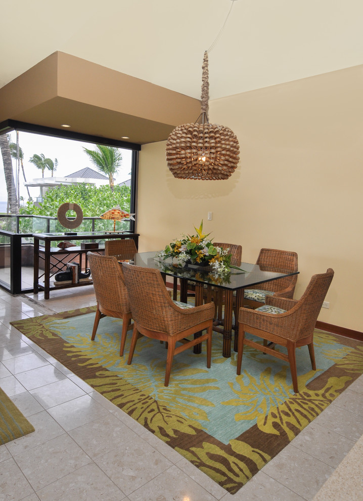 Photo of a mid-sized tropical kitchen/dining combo in Hawaii with beige walls, a hanging fireplace and beige floor.