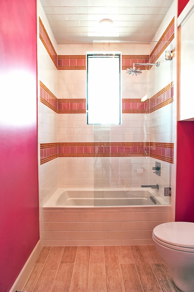 Photo of a transitional bathroom in Austin with an alcove tub, a shower/bathtub combo, pink tile and pink walls.