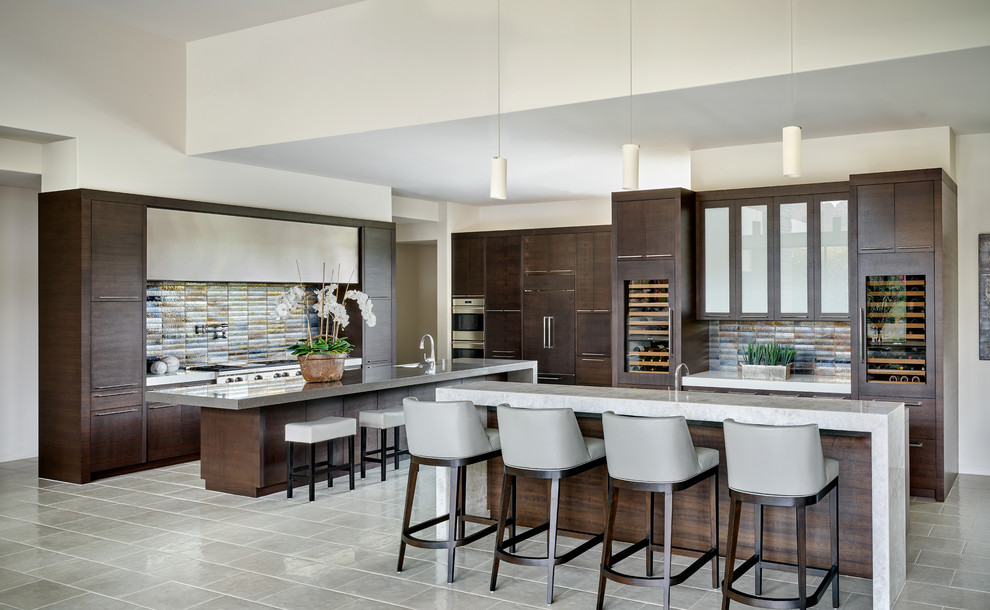 Design ideas for a large modern u-shaped open plan kitchen in Phoenix with an undermount sink, flat-panel cabinets, dark wood cabinets, solid surface benchtops, metallic splashback, ceramic splashback, stainless steel appliances, multiple islands, white floor and white benchtop.