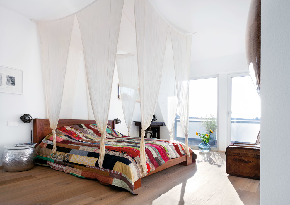 Design ideas for a large eclectic master bedroom in Stuttgart with white walls, light hardwood floors and no fireplace.