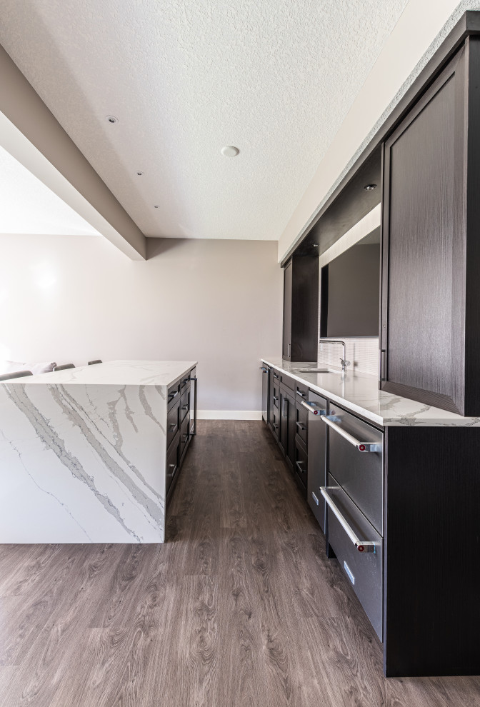 This is an example of a mid-sized modern walk-out basement in Calgary with a home bar, beige walls, vinyl floors, no fireplace, brown floor and wallpaper.