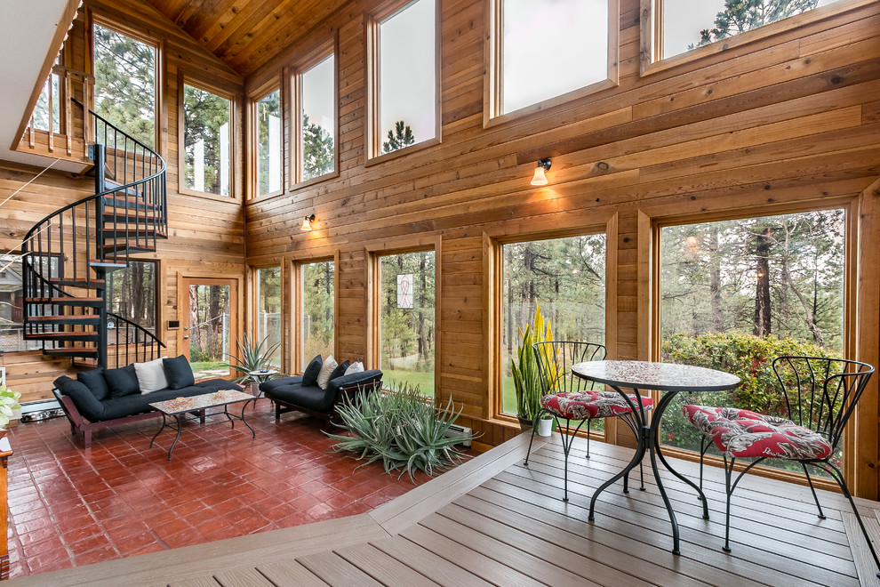 This is an example of a large country sunroom in Denver with a standard ceiling and red floor.