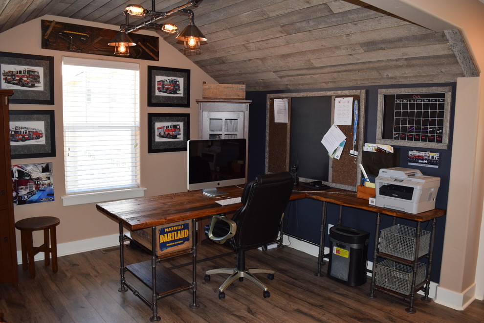 This is an example of a small industrial study room in Denver with dark hardwood floors, a freestanding desk and black walls.