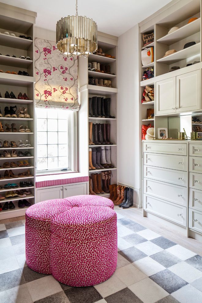 This is an example of a mid-sized transitional women's dressing room in New York with flat-panel cabinets, grey cabinets and light hardwood floors.