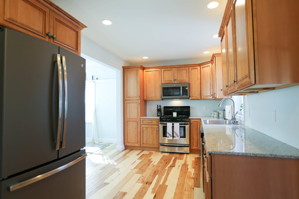 Example of a transitional light wood floor kitchen design in Bridgeport with granite countertops