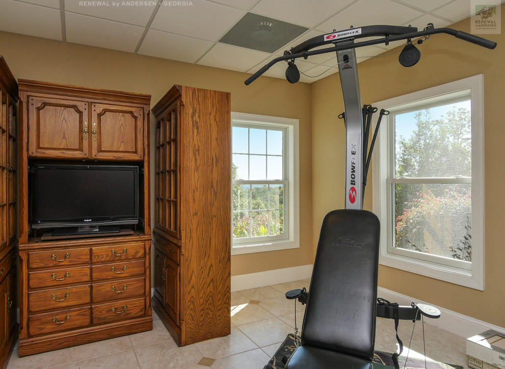This is an example of a mid-sized home weight room in Atlanta with yellow walls, ceramic floors, beige floor and recessed.