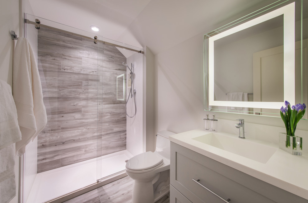 Mid-sized traditional bathroom in DC Metro with recessed-panel cabinets, grey cabinets, an alcove shower, a one-piece toilet, multi-coloured tile, glass tile, grey walls, porcelain floors and an undermount sink.