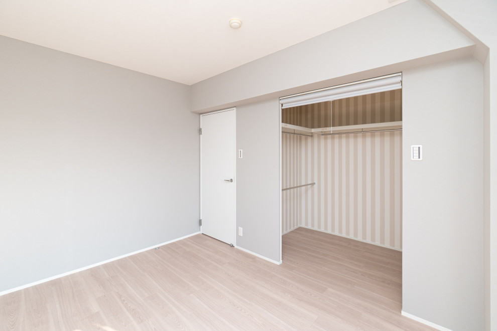 Foto di una camera da letto nordica con pavimento in compensato, pavimento marrone, soffitto in carta da parati e carta da parati