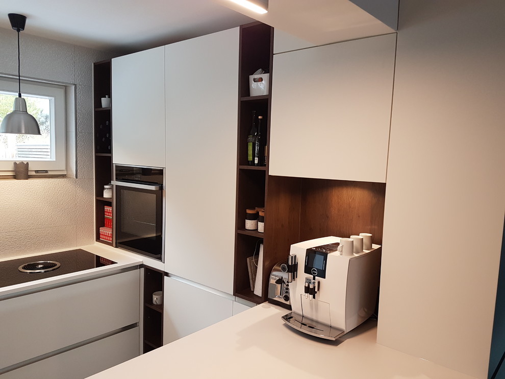 Contemporary u-shaped kitchen in Stuttgart with white cabinets.