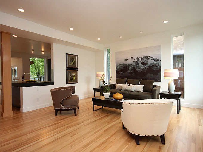 This is an example of a mid-sized contemporary open concept living room in Calgary with white walls, light hardwood floors and no tv.