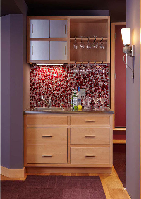 Design ideas for a small transitional single-wall wet bar in Other with an integrated sink, flat-panel cabinets, light wood cabinets, red splashback, light hardwood floors and brown floor.