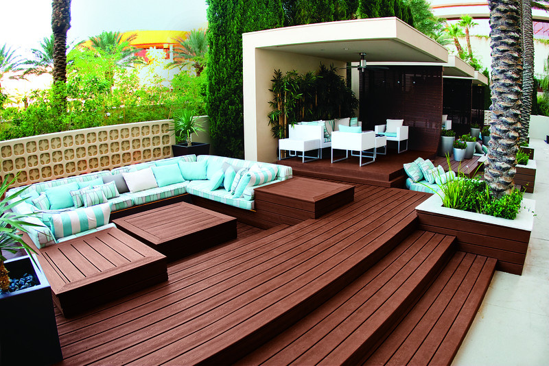 Example of a large trendy backyard deck design with a roof extension