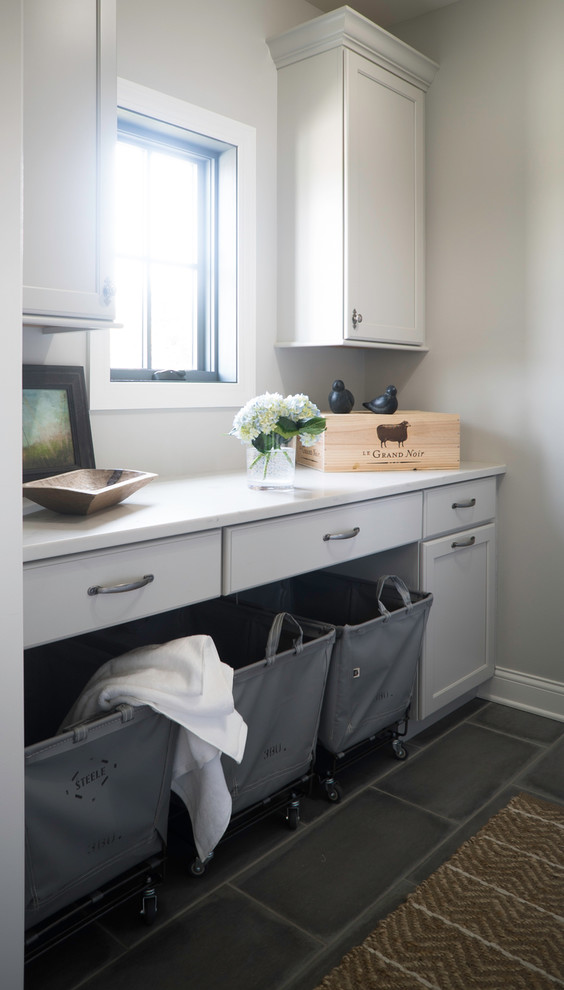 Laundry room - mid-sized farmhouse porcelain tile and gray floor laundry room idea in St Louis with white cabinets, quartz countertops, beige walls, a side-by-side washer/dryer and recessed-panel cabinets