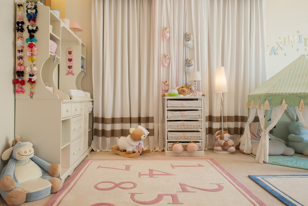 Transitional nursery with beige walls and carpet for girls.