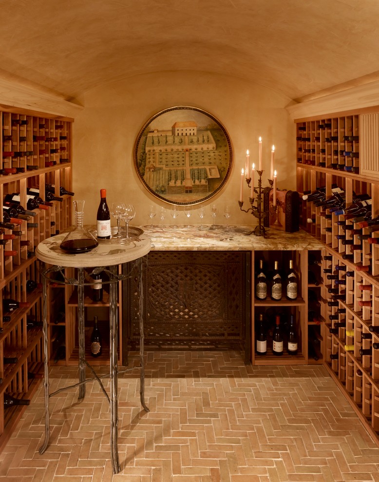 This is an example of a mid-sized mediterranean wine cellar in Other with terra-cotta floors and storage racks.