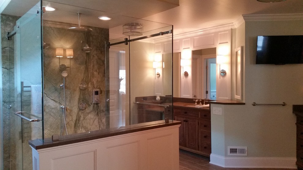 This is an example of a large country master bathroom in New York with an undermount sink, beaded inset cabinets, medium wood cabinets, wood benchtops, a freestanding tub, a double shower, a two-piece toilet, green tile, stone slab, green walls and porcelain floors.