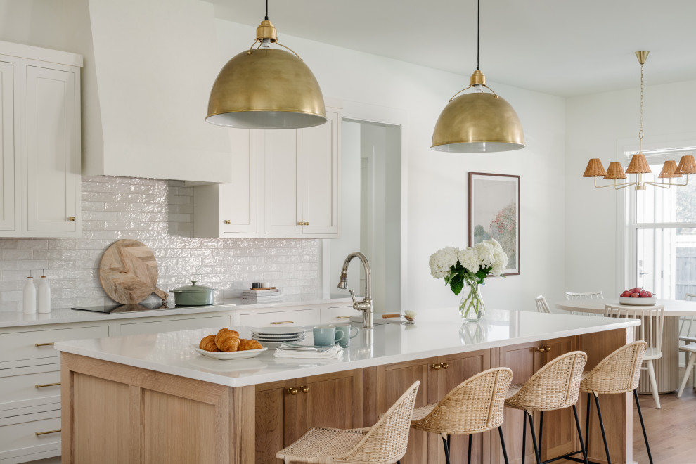 This is an example of a transitional eat-in kitchen in Jacksonville with a farmhouse sink, shaker cabinets, beige cabinets, quartz benchtops, beige splashback, subway tile splashback, stainless steel appliances, medium hardwood floors, with island, brown floor and white benchtop.