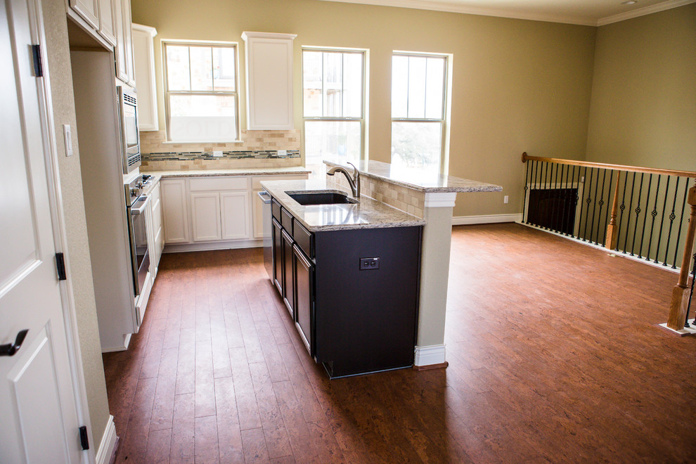 Eat-in kitchen - mid-sized transitional l-shaped medium tone wood floor eat-in kitchen idea in Austin with an undermount sink, recessed-panel cabinets, white cabinets, granite countertops, beige backsplash, stone tile backsplash, stainless steel appliances and an island