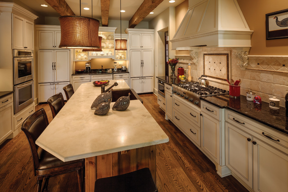 Large transitional medium tone wood floor kitchen photo with shaker cabinets, white cabinets, marble countertops, multicolored backsplash, stone tile backsplash, stainless steel appliances and an island
