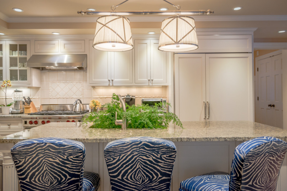 Example of a mid-sized transitional l-shaped open concept kitchen design in Boston with an undermount sink, beaded inset cabinets, white cabinets, granite countertops, beige backsplash, porcelain backsplash, paneled appliances and an island