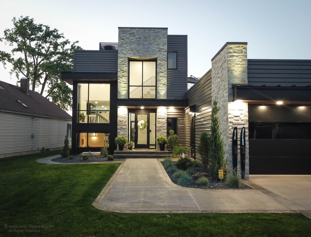 Inspiration för ett stort funkis svart hus, med två våningar, metallfasad, platt tak och tak i mixade material