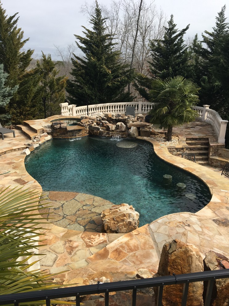 Mid-sized modern backyard custom-shaped aboveground pool in Atlanta with a water feature and natural stone pavers.