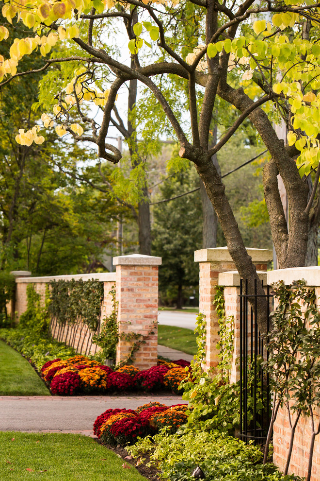 Design ideas for a large traditional front yard full sun driveway for fall in Chicago with brick pavers.
