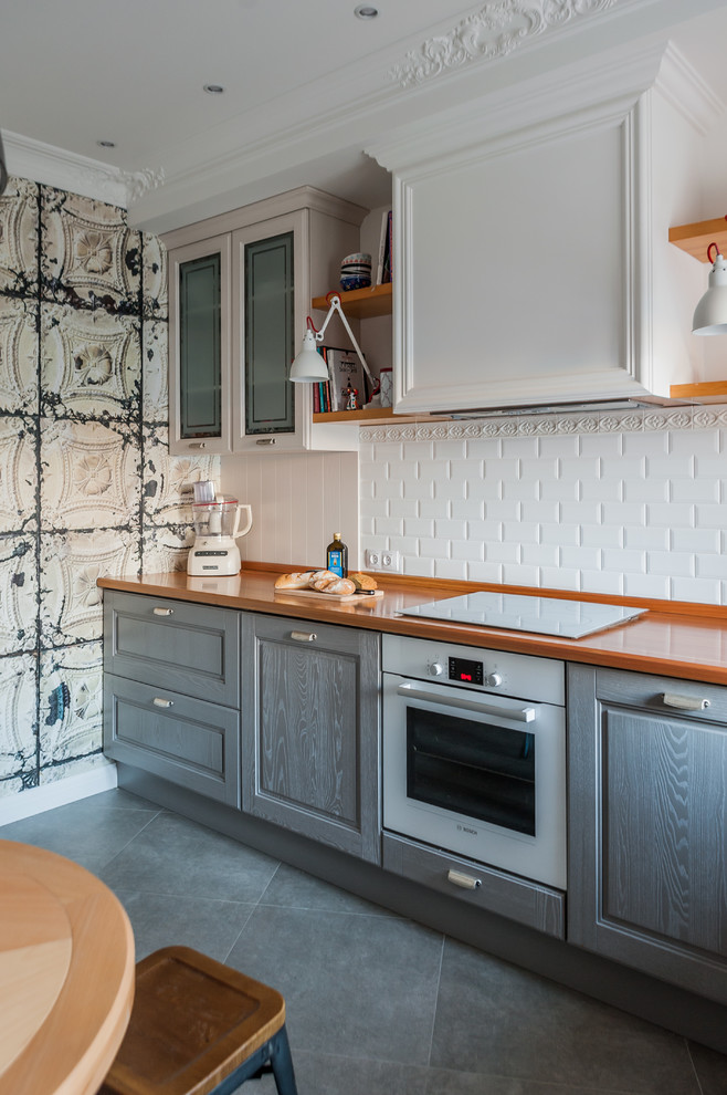 Inspiration for a mid-sized contemporary l-shaped separate kitchen in Other with a double-bowl sink, raised-panel cabinets, grey cabinets, wood benchtops, white splashback, ceramic splashback, coloured appliances, porcelain floors and grey floor.
