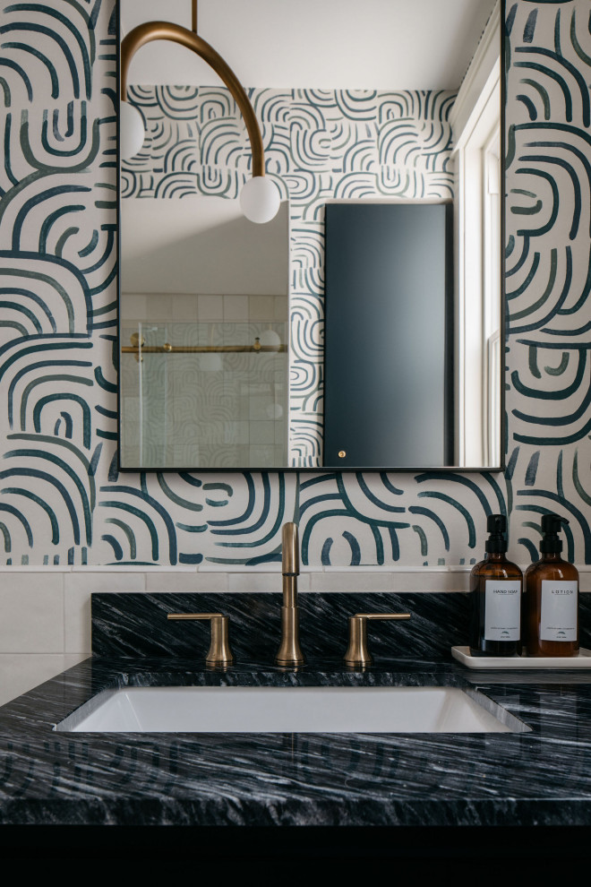Photo of a mid-sized transitional bathroom in Chicago with recessed-panel cabinets, black cabinets, a one-piece toilet, white tile, ceramic tile, multi-coloured walls, mosaic tile floors, a drop-in sink, quartzite benchtops, multi-coloured floor, black benchtops, a single vanity, a built-in vanity and wallpaper.