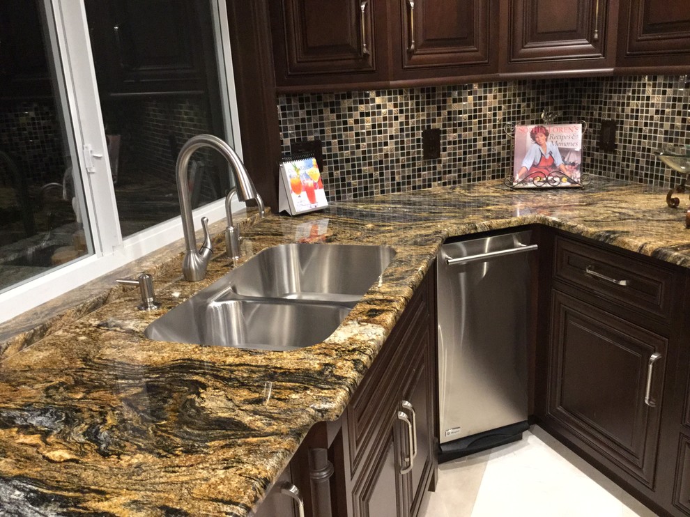 Contemporary u-shaped kitchen in Miami with an undermount sink, dark wood cabinets, granite benchtops, mosaic tile splashback, stainless steel appliances and marble floors.