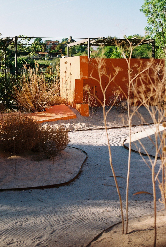 Immagine di un grande giardino minimalista esposto a mezz'ombra in cortile con ghiaia
