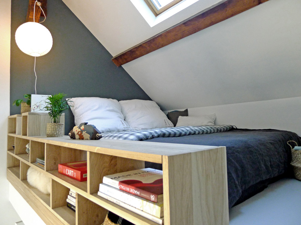 Mittelgroßes Schlafzimmer im Loft-Style mit grauer Wandfarbe, gebeiztem Holzboden, weißem Boden und freigelegten Dachbalken in Paris