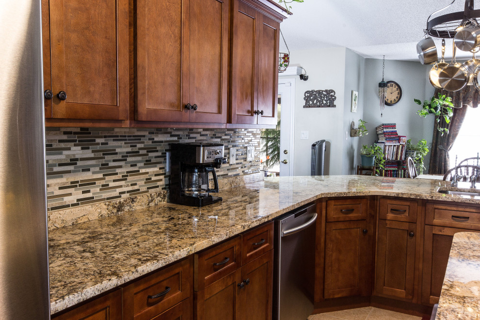 Inspiration for a mid-sized galley cement tile floor and beige floor eat-in kitchen remodel with an undermount sink, shaker cabinets, medium tone wood cabinets, granite countertops, multicolored backsplash, glass sheet backsplash, stainless steel appliances, an island and beige countertops
