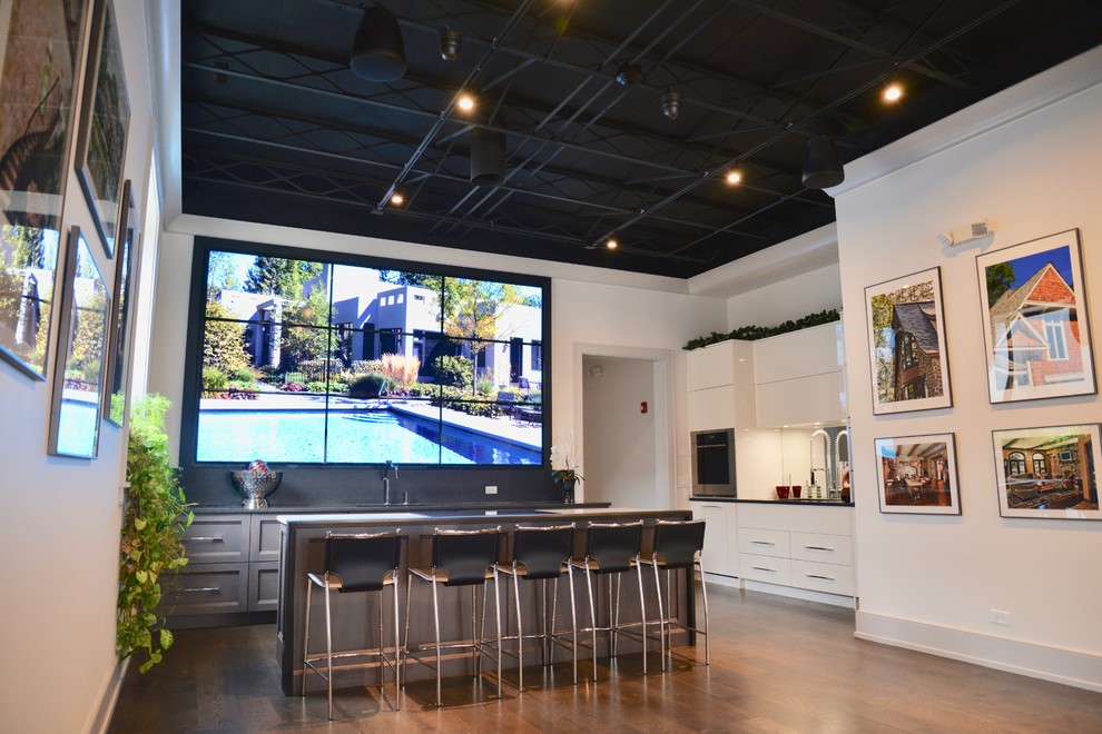 Open concept kitchen - huge transitional l-shaped dark wood floor open concept kitchen idea in Chicago with an undermount sink, recessed-panel cabinets, gray cabinets, granite countertops, black backsplash, stone tile backsplash, paneled appliances and an island