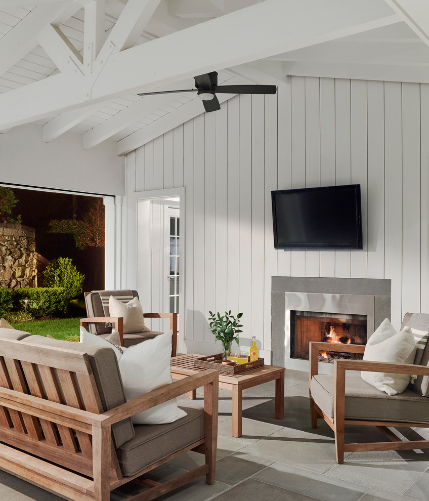 Design ideas for a beach style verandah in Boston with with fireplace and a roof extension.