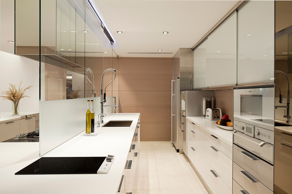 This is an example of a contemporary galley kitchen pantry in Perth with an undermount sink, flat-panel cabinets, white cabinets, granite benchtops, brown splashback, glass sheet splashback, stainless steel appliances and no island.