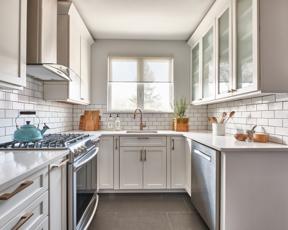 Photo of a small transitional u-shaped eat-in kitchen in New York with an undermount sink, shaker cabinets, white cabinets, quartzite benchtops, white splashback, subway tile splashback, stainless steel appliances, porcelain floors, no island, white benchtop and grey floor.