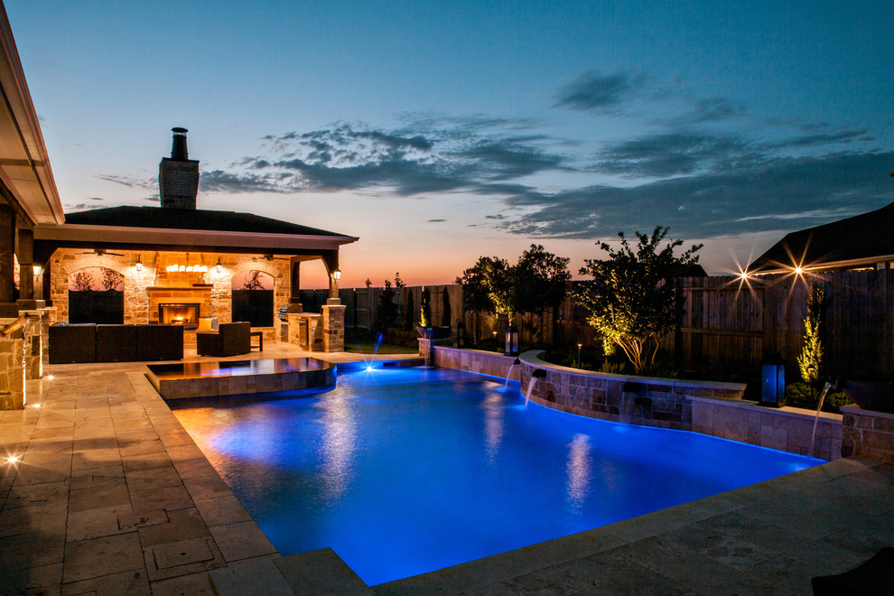 Large modern backyard custom-shaped lap pool in Houston with a hot tub and natural stone pavers.