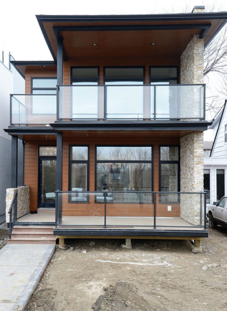 Photo of a mid-sized contemporary two-storey brown exterior in Other with wood siding.