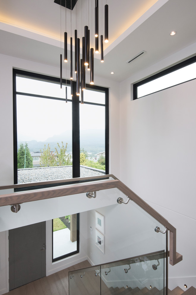 Mid-sized modern foyer in Vancouver with grey walls, medium hardwood floors, a single front door, a medium wood front door and brown floor.