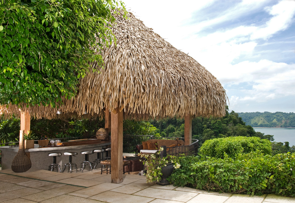 This is an example of a tropical patio in Other with a gazebo/cabana.