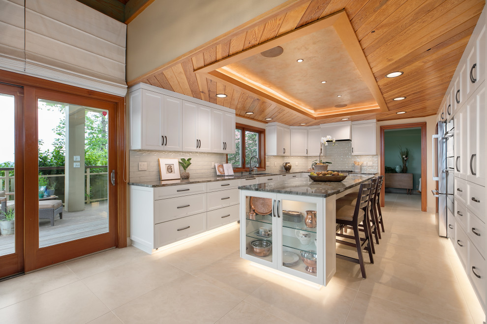 Inspiration for a large classic u-shaped kitchen/diner in Portland with a submerged sink, recessed-panel cabinets, white cabinets, quartz worktops, white splashback, glass tiled splashback, stainless steel appliances, porcelain flooring, an island, beige floors, grey worktops and a drop ceiling.
